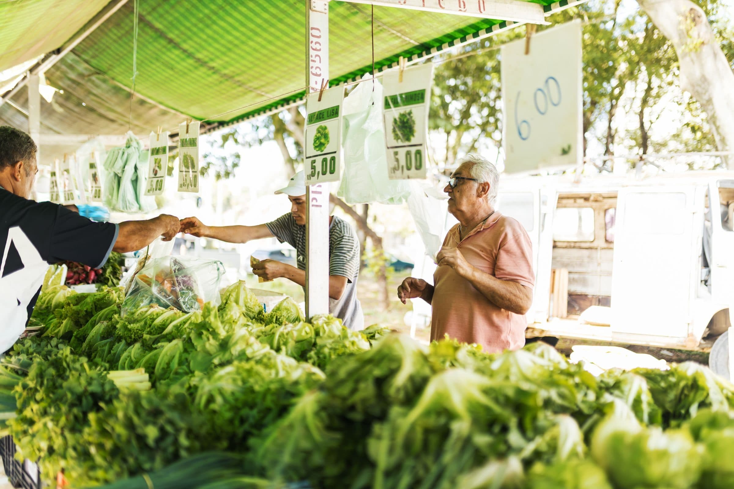 A produce stall owner taking payment from a customer